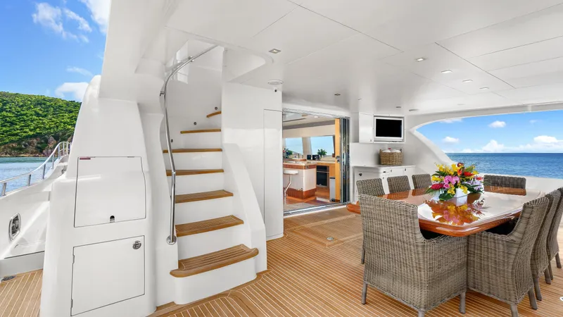 Sea Glass Yacht Photos Pics Luxurious Horizon PC74 yacht interior with dining area, wooden flooring, and ocean view.