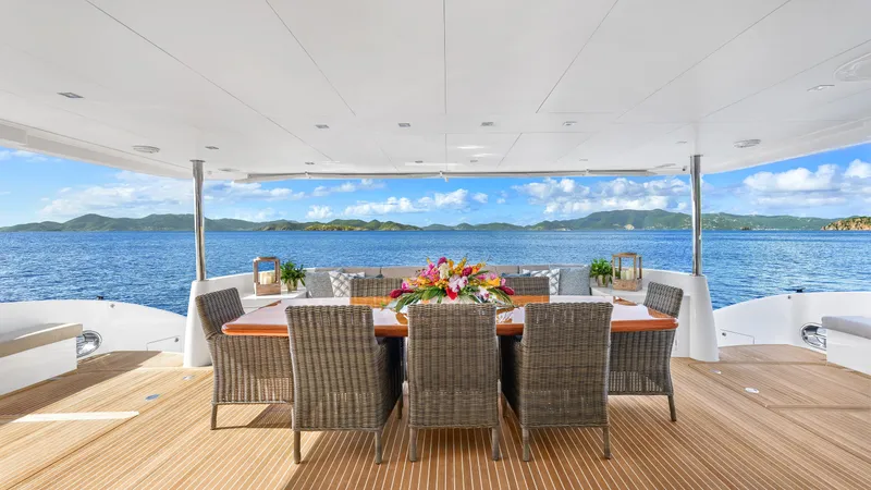 Sea Glass Yacht Photos Pics Luxurious Horizon PC74 yacht deck with dining area, ocean view, and elegant wicker chairs, 2018 model.