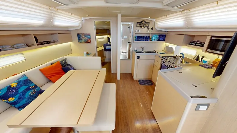 Evelyn Yacht Photos Pics Luxurious interior of 2021 Beneteau Oceanis 40.1 yacht with modern kitchen and cozy seating area.