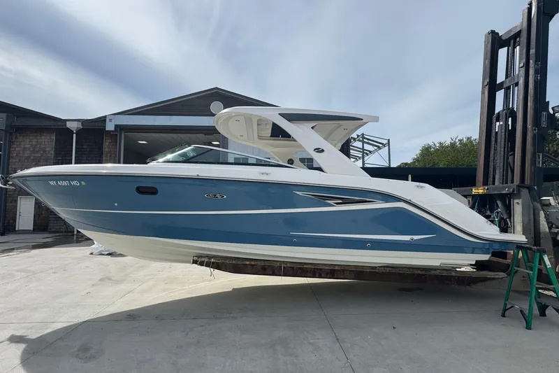  Yacht Photos Pics 2021 Sea Ray 310 SLX boat in a marina, side view, blue and white design.
