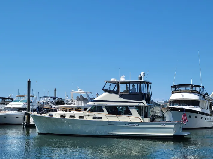 No Agenda Yacht Photos Pics 1982 Tollycraft 48' Sedan yacht docked in a marina under clear blue skies.