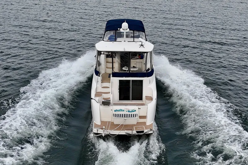 Shake N' Bake Yacht Photos Pics 2006 Meridian Motoryacht cruising on open water, rear view.