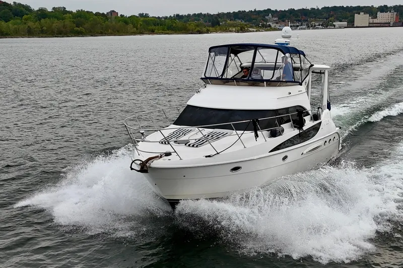 Shake N' Bake Yacht Photos Pics 2006 Meridian Motoryacht cruising on a lake with lush green shoreline.