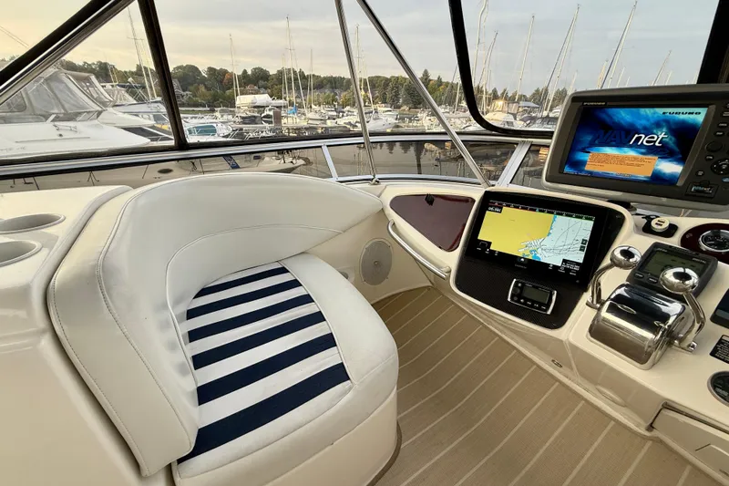Shake N' Bake Yacht Photos Pics 2006 Meridian Motoryacht helm with navigation screens and striped seating, docked at marina.