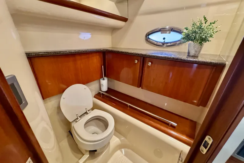 Shake N' Bake Yacht Photos Pics Luxurious 2006 Meridian Motoryacht bathroom with wooden cabinets and porthole window.