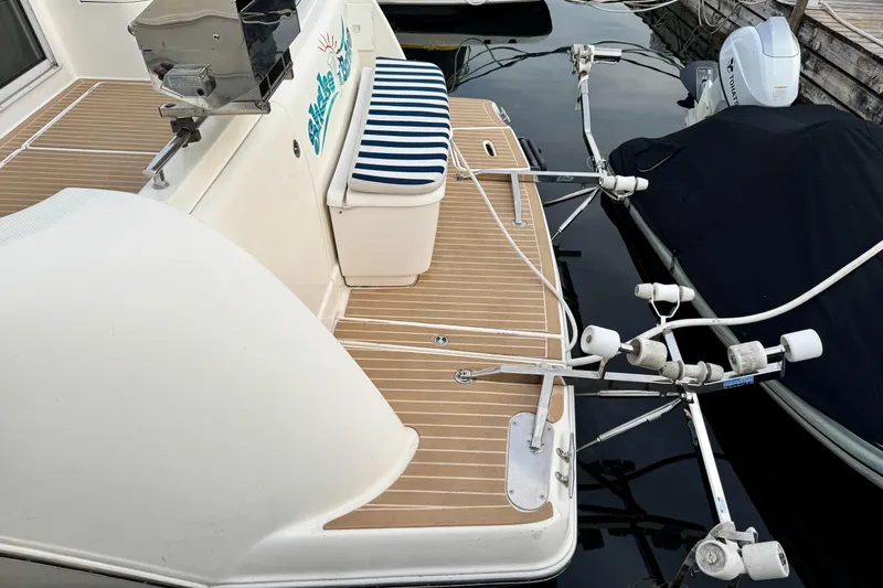 Shake N' Bake Yacht Photos Pics 2006 Meridian Motoryacht deck with striped cushion and fishing rod holders.