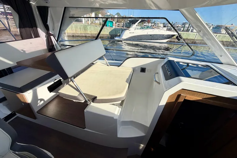 Yacht Photos Pics Interior view of 2021 Beneteau Antares 9 boat, featuring seating and table setup.