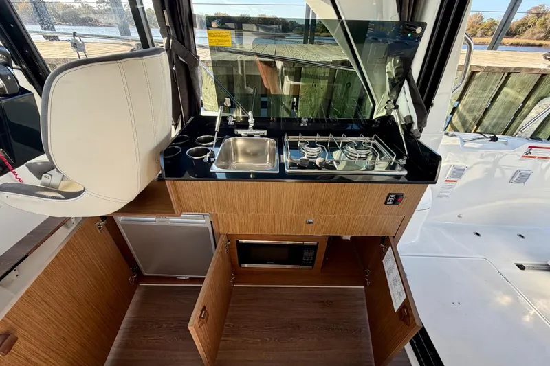  Yacht Photos Pics Interior of 2021 Beneteau Antares 9 with kitchenette, stove, sink, and microwave.