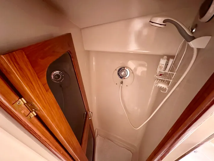 Sea Suite Yacht Photos Pics Shower area in 1989 Viking 44 Motor Yacht with wooden cabinet and showerhead.