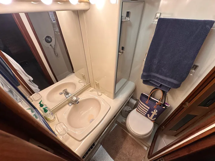 Sea Suite Yacht Photos Pics Bathroom interior of 1989 Viking 44 Motor Yacht with sink, mirror, and nautical decor.