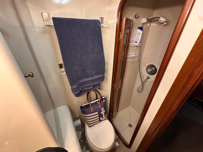 Sea Suite Yacht Photos Pics 1989 Viking 44 Motor Yacht bathroom with shower, toilet, towel, and nautical-themed bag.