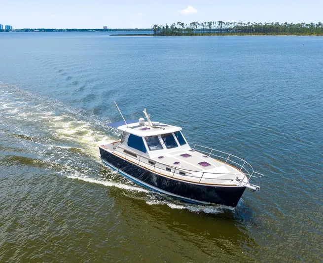 True Blue Yacht Photos Pics 2005 Sabre 42 Express yacht cruising on a calm, scenic waterway.