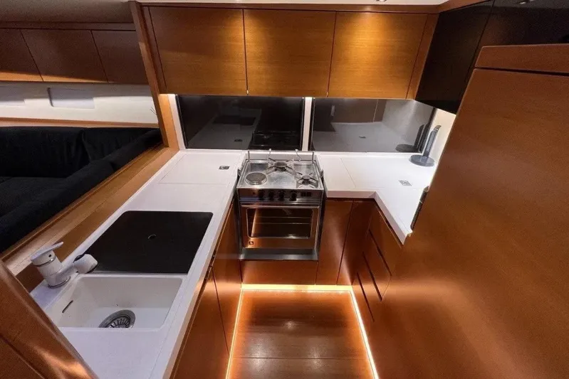 SueÑo Yacht Photos Pics Modern kitchen interior of 2016 Ice Yachts 62, featuring sleek wood cabinetry and integrated appliances.
