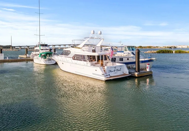 Five O'clock Yacht Photos Pics West Bay 58 Sonship yacht docked in marina, 2000 model, calm waters, clear sky.