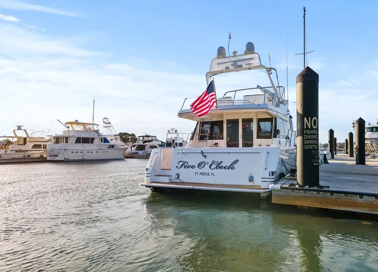 Five O'clock Yacht Photos Pics West Bay 58 Sonship yacht docked at marina, displaying American flag, 2000 model.