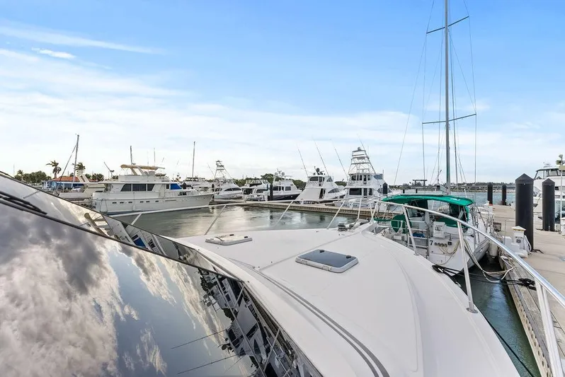 Five O'clock Yacht Photos Pics Luxury yachts docked at marina, featuring 2000 West Bay 58 Sonship under clear blue sky.