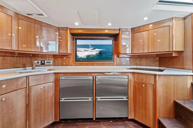 Hog Wild Yacht Photos Pics Luxurious kitchen interior of 2007 Viking 52 Open yacht with wooden cabinetry and ocean view.