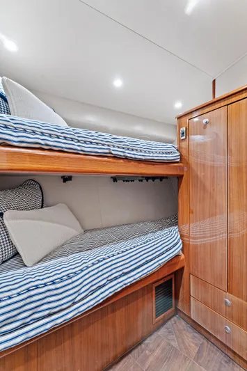 Hog Wild Yacht Photos Pics 2007 Viking 52 Open yacht cabin with wooden bunk beds and striped bedding.