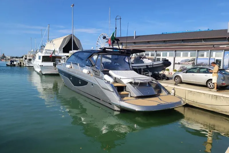 Cranchi St 60 2023 Yacht Photos Pics 2023 Cranchi 60 ST yacht docked at a marina under clear blue skies.