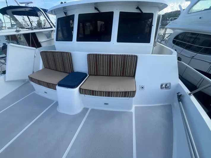 September Song Yacht Photos Pics 2007 DeFever 55 yacht with cushioned seating on deck.