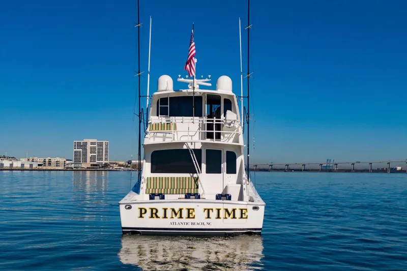 Prime Time Yacht Photos Pics 2002 Viking 65 Enclosed Bridge yacht on calm water, cityscape in background.