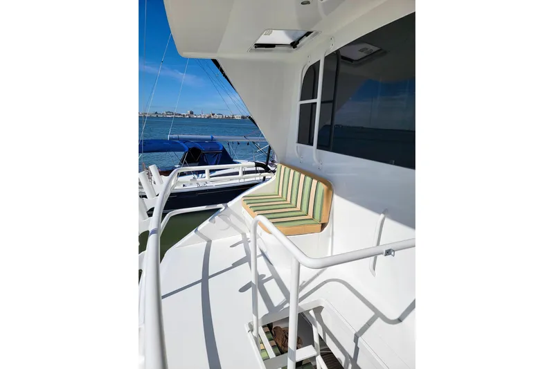 Prime Time Yacht Photos Pics 2002 Viking 65 Enclosed Bridge yacht deck with striped seating, overlooking the ocean.
