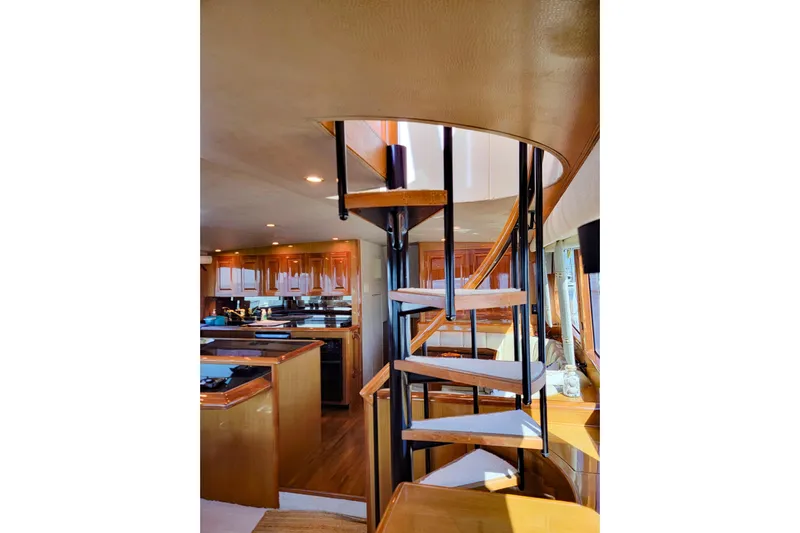 Prime Time Yacht Photos Pics Interior of 2002 Viking 65 Enclosed Bridge yacht with spiral staircase and wooden cabinetry.