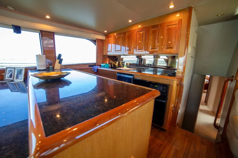 Prime Time Yacht Photos Pics Luxurious kitchen interior of 2002 Viking 65 Enclosed Bridge yacht with wooden cabinetry.