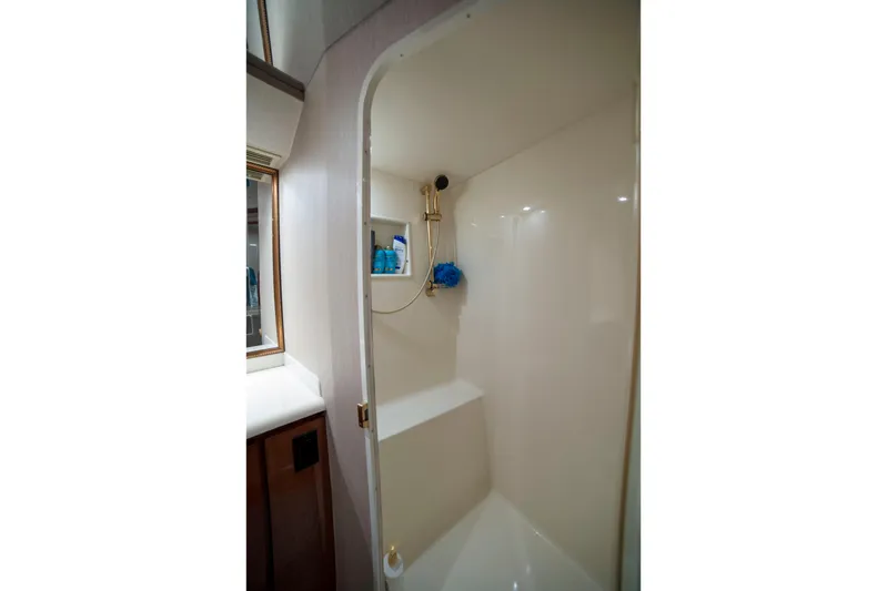 Prime Time Yacht Photos Pics Shower area inside 2002 Viking 65 Enclosed Bridge yacht, featuring sleek design and storage shelves.