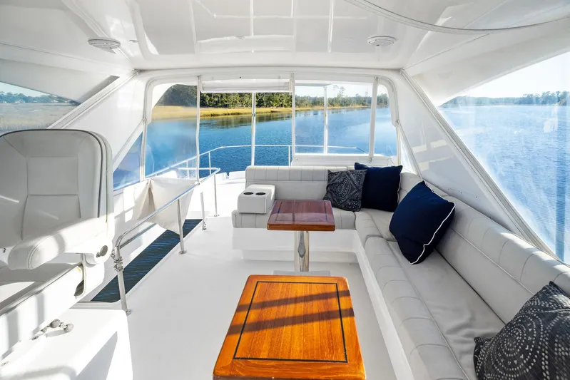 Bonefish Yacht Photos Pics Luxurious interior of 2016 Hatteras M60 yacht with plush seating and scenic water view.