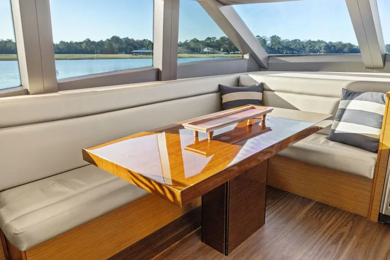 Bonefish Yacht Photos Pics Luxurious interior of 2016 Hatteras M60 yacht with elegant wood table and plush seating.