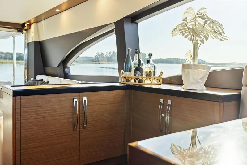 Bonefish Yacht Photos Pics Luxurious interior of 2016 Hatteras M60 yacht with elegant cabinetry and scenic window view.
