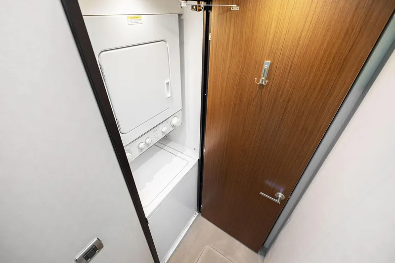 Bonefish Yacht Photos Pics Compact laundry area in 2016 Hatteras M60 yacht with stacked washer and dryer.