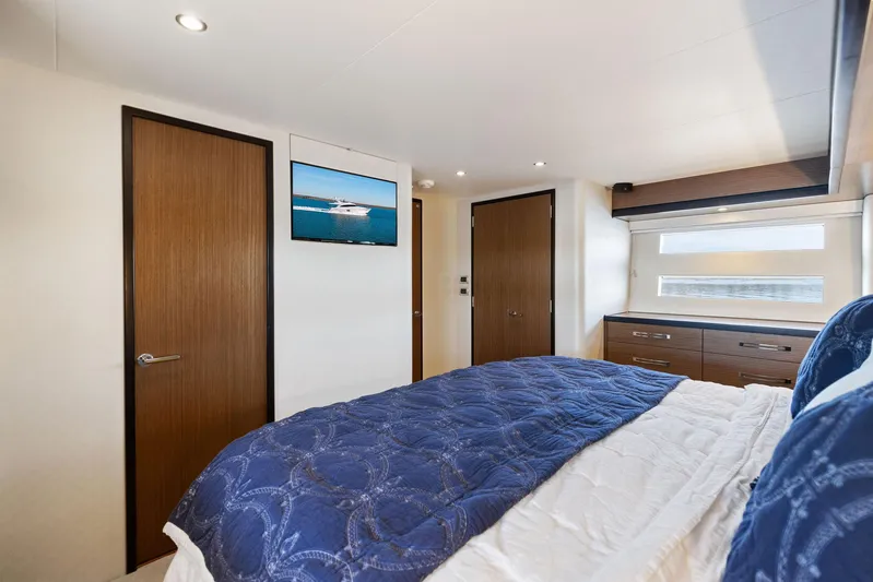 Bonefish Yacht Photos Pics Luxurious bedroom interior of 2016 Hatteras M60 yacht with blue bedding and modern decor.