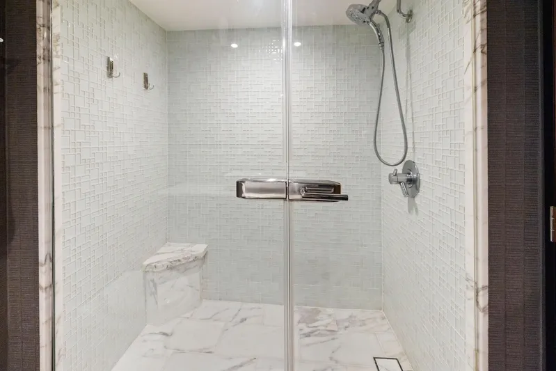 Bonefish Yacht Photos Pics Luxurious shower in 2016 Hatteras M60 yacht with marble tiles and modern fixtures.