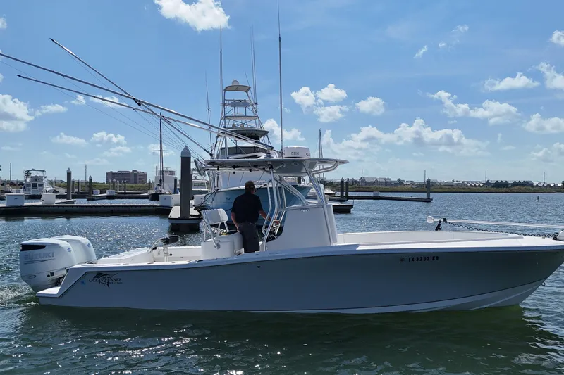 Cherokee Yacht Photos Pics 2022 Ocean Runner 29 Center Console boat docked in a marina under a clear sky.