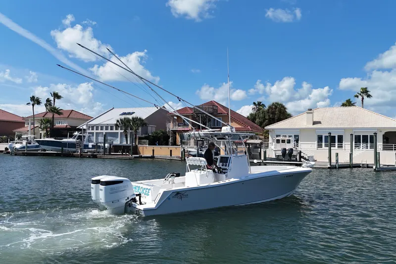 Cherokee Yacht Photos Pics 2022 Ocean Runner 29 Center Console boat cruising near waterfront homes under blue skies.