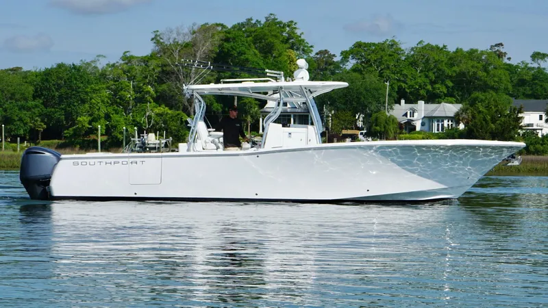  Yacht Photos Pics 2018 Southport 33 FE boat on calm water, surrounded by lush greenery.