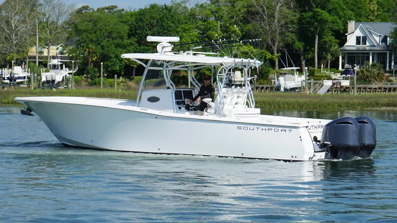  Yacht Photos Pics 2018 Southport 33 FE boat cruising on a calm river with lush greenery in the background.