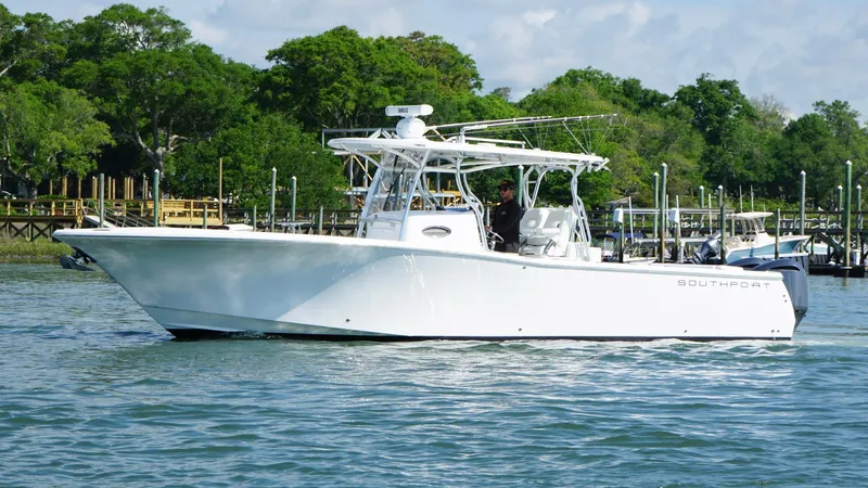  Yacht Photos Pics 2018 Southport 33 FE boat on calm water, surrounded by lush greenery.