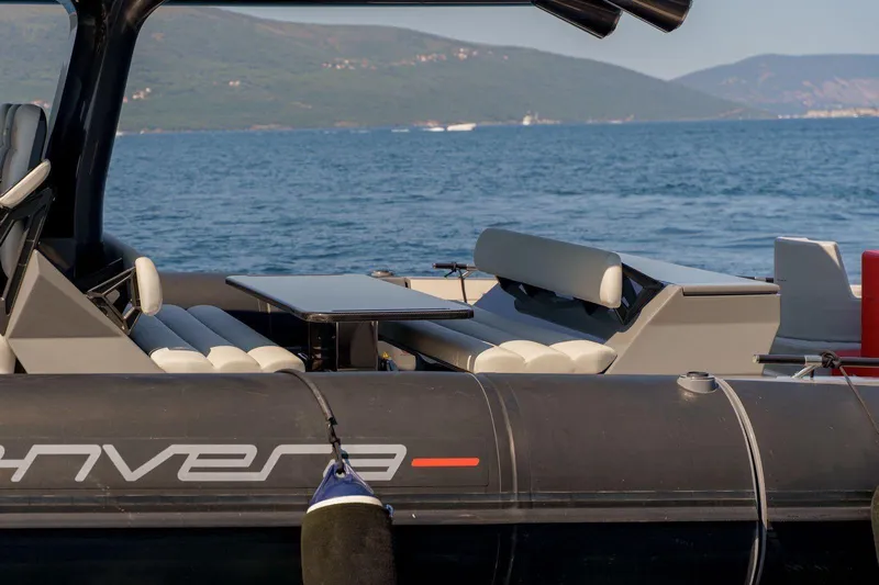  Yacht Photos Pics 2023 Anvera 48 boat interior with seating and table, set against a scenic ocean backdrop.
