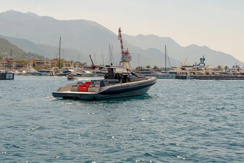  Yacht Photos Pics 2023 Anvera 48 luxury yacht cruising in a scenic harbor with mountains in the background.