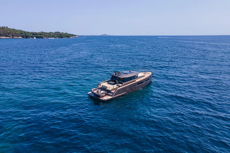 M/y Rubi Yacht Photos Pics 2024 Pardo Yachts GT52 cruising on open blue sea near lush coastline.
