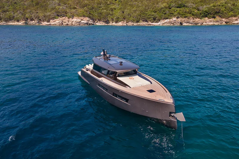 M/y Rubi Yacht Photos Pics 2024 Pardo Yachts GT52 cruising on clear blue waters near a lush coastline.