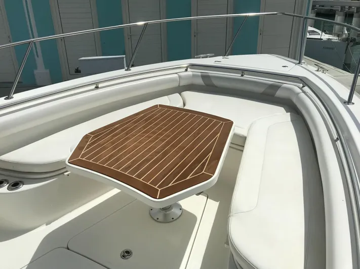 Endless Summer Yacht Photos Pics 2014 Boston Whaler 320 Outrage with wooden table in seating area.