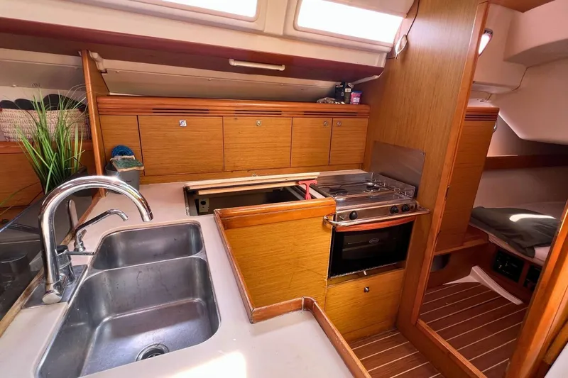  Yacht Photos Pics 2008 Jeanneau Sun Odyssey 42i Performance yacht interior with kitchen, sink, stove, and wooden cabinetry.