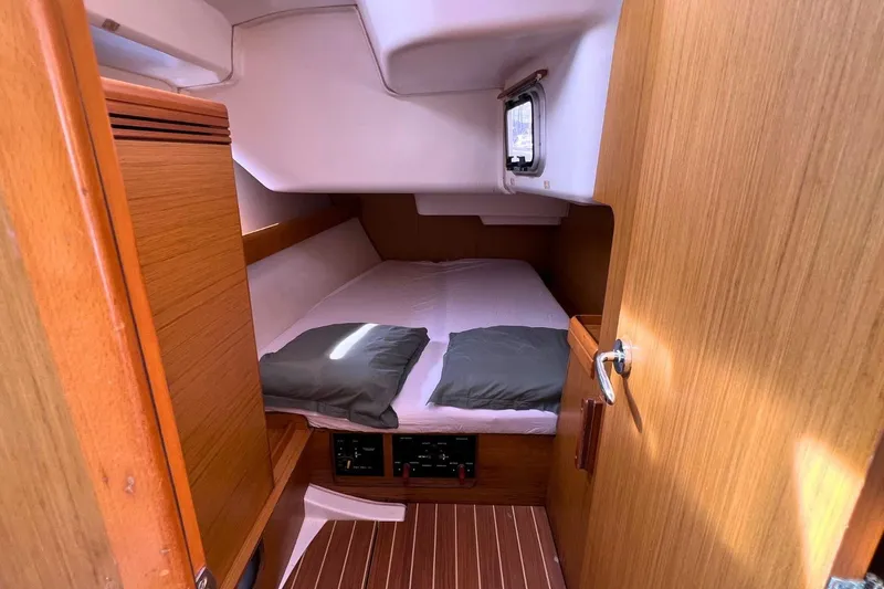  Yacht Photos Pics Cabin interior of 2008 Jeanneau Sun Odyssey 42i Performance yacht, featuring a cozy bed and wooden finish.