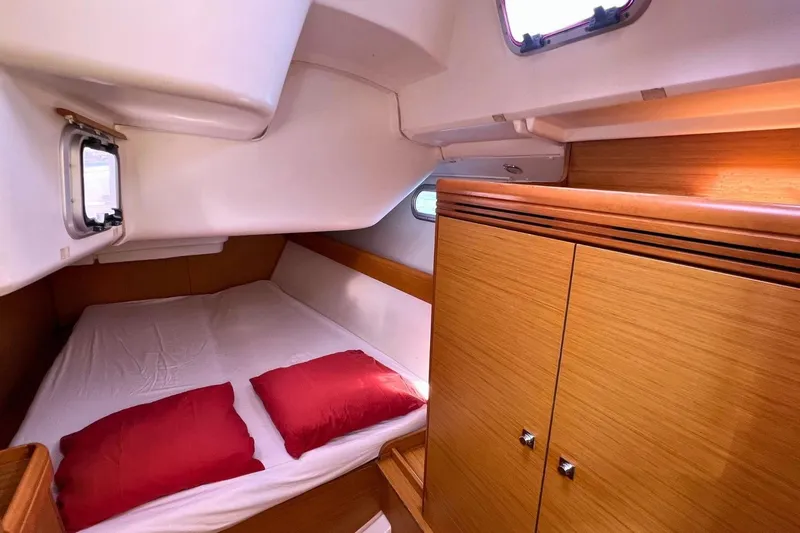  Yacht Photos Pics Cozy cabin interior of 2008 Jeanneau Sun Odyssey 42i Performance yacht with red pillows.