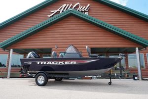 2026 Tracker Pro Guide V-16 WT boat displayed outside a log cabin-style building.