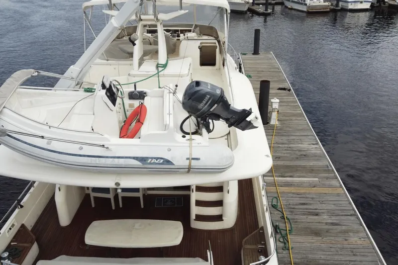  Yacht Photos Pics Luxury 2001 Viking Princess 72 yacht docked, featuring spacious deck and tender boat.